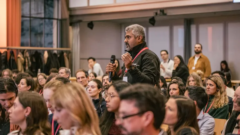 A man from the audience stood up from his seat to ask the panellists a question, microphone in hand.